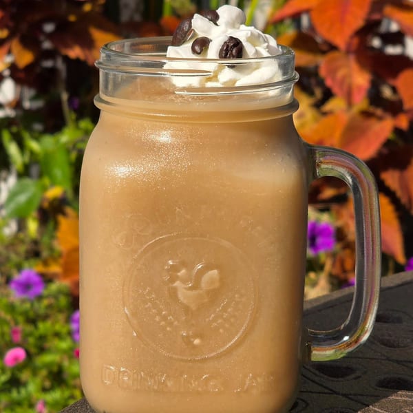 A Label Kitchen + Bar frozen coffee drink with whipped cream and coffee beans in a mason jar.