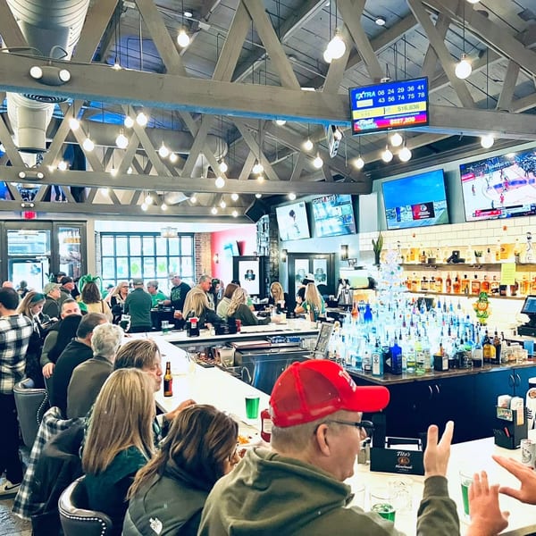 Patrons enjoying drinks and watching sports at the lively Label Kitchen + Bar.
